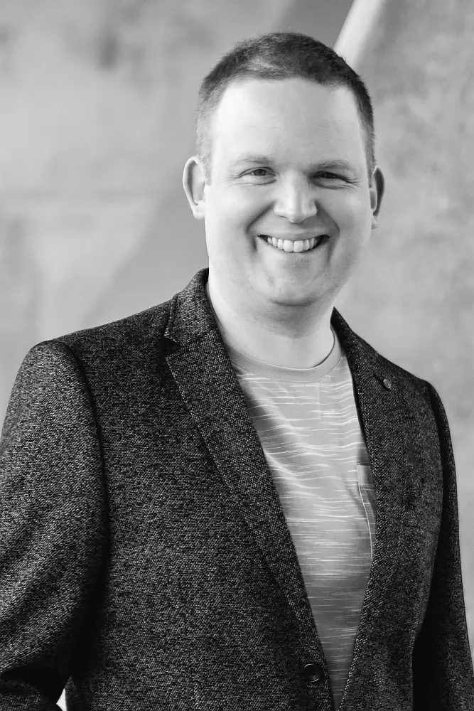 Texter Tobias Vasen von der Karlsruher Kommunikationsagentur MINDING GAPS steht vor einer Betonwand
