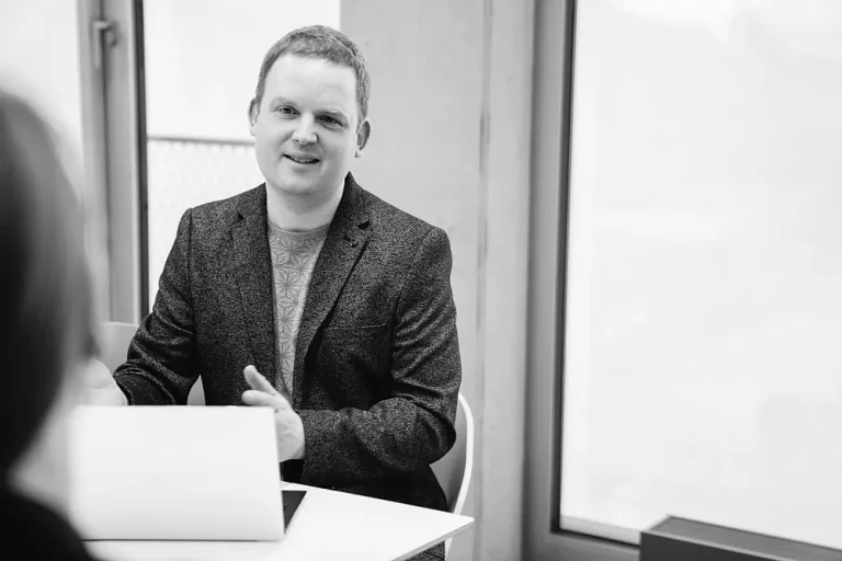 Tobias Vasen von der Kommunikationsagentur MINDING GAPS sitzt in einem Kundengespräch